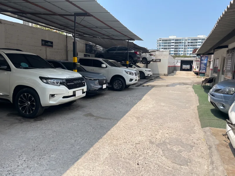 Patio del taller con camionetas parqueadas bajo el techo