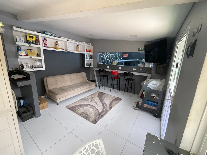 Sala de espera del taller, con sofá, mesa alta y aire acondicionado