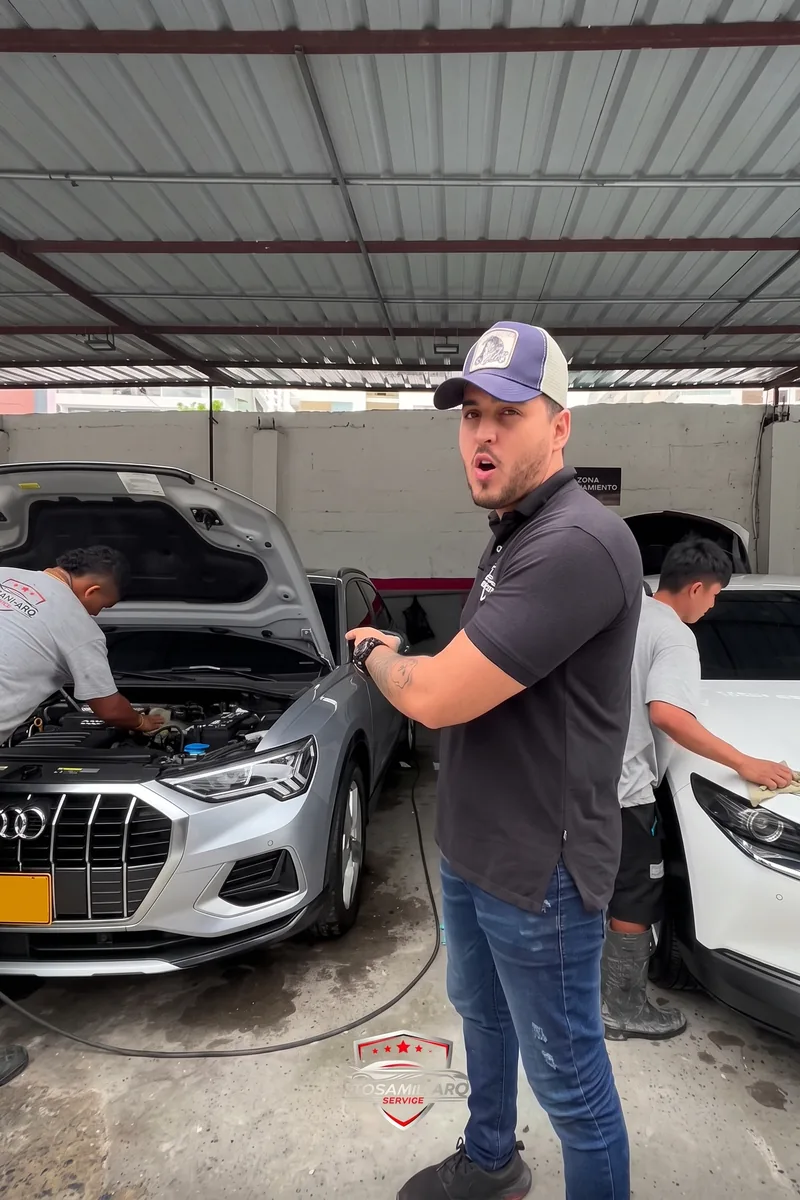 Técnico del taller revisando un carro con el capó abierto